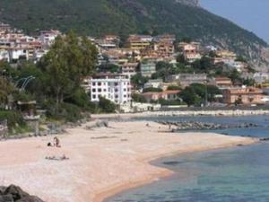 a beach with people on the sand and buildings at Le Pavoncelle Blu in Cala Gonone