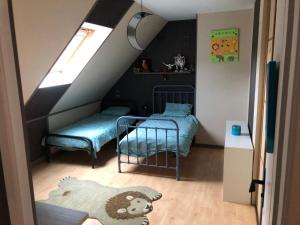 a small bedroom with a bed and a staircase at Maison avec piscine 10 minutes du circuit 24h in Fillé