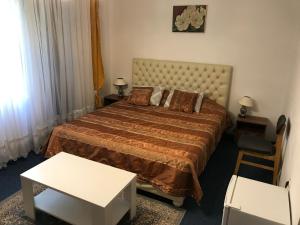 a bedroom with a large bed and a white table at Madam Svetlana in Tivat