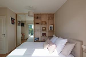 um quarto com uma cama grande e almofadas brancas em Un Appartement PENTHOUSE d'Exception sur le Port de Vannes em Vannes