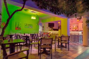 un restaurante con paredes verdes, mesas de madera y sillas en Costas & Chrysoula, en Plakias
