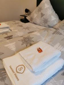einen Stapel Handtücher auf dem Bett in der Unterkunft FeWo An der Elpe zwischen Winterberg und Fort Fun in Olsberg