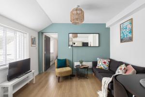 a living room with a couch and a tv at Albany 2 by Black Door Stays in Cardiff