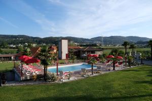 una piscina con sillas y sombrillas en un complejo en Aldeia da Quinta do Paço en Santo Tirso