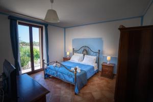 a bedroom with a blue bed and a window at - Vista Egadi - in Torre Nubia