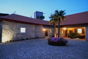 una casa con una palmera y un edificio en Aldeia da Quinta do Paço, en Santo Tirso