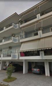 a large apartment building with cars parked in front of it at Blue Lagoon Studio 2 in Mesolongion