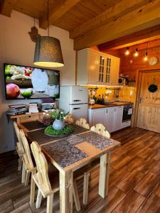 een keuken met een houten tafel met stoelen en een eetkamer bij Domki Tatrzańskie Kącina in Murzasichle