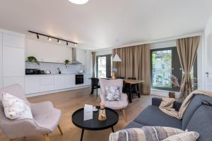 a living room with a couch and chairs and a table at EXCLUSIVE Aparthotel Kraków Lubicz 40 in Krakow