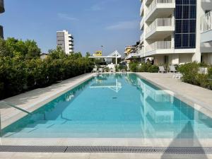 uma grande piscina ao lado de um edifício em Blu Homes Apartments EfStyle Hotel em Lido di Jesolo