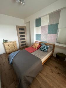 a bedroom with a bed and a dresser at Apartament Poznańska in Suwałki