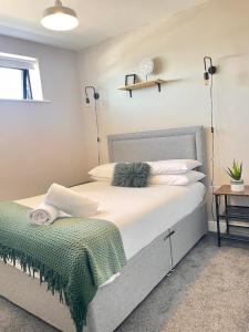 a bedroom with a large bed with a green blanket on it at Poole Quay Sea View with Parking in Poole