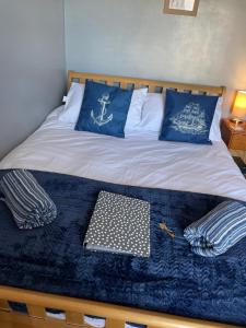 a bed with a blue blanket and blue pillows on it at Craig Avad in Holyhead
