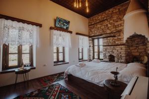 a bedroom with a large bed and a stone wall at Tradita e Beratit in Berat