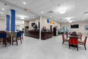 a lobby with tables and chairs and a cafeteria at Comfort Inn & Suites St Louis-Hazelwood in Hazelwood