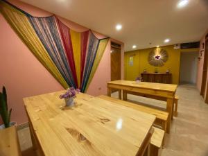 Habitación con 2 mesas de madera y cortina en BROTHERs HOUSE, en Cusco