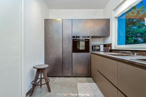 a kitchen with a stainless steel refrigerator and a stool at Villa Ca Damare, TerreMarine in Le Grazie