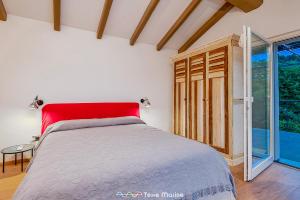 a bedroom with a red bed and a large window at Villa Ca Damare, TerreMarine in Le Grazie