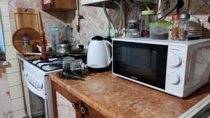 a kitchen counter with a microwave and a stove at Аренда квартиры или комнат в квартире in Zhmerynka