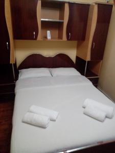 a bed with two white towels on top of it at Pensiune Restaurant Brândușa in Suceava