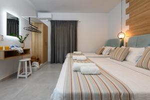 a hotel room with two beds with towels on them at Luxury Sirens Fresh in Limenas