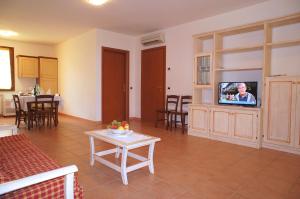 a living room with a tv and a table at Appartamenti in Residence Villa Santa Maria in San Vincenzo