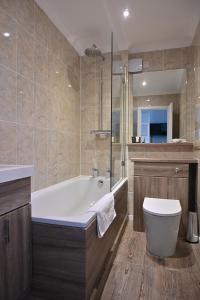 a bathroom with a bath tub and a toilet at Toravaig House Hotel in Teangue