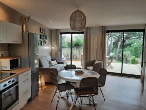 a kitchen and living room with a table and chairs at Le Cottage du Bois Flotté in Saint Malo