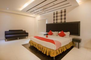 um quarto com uma cama grande e uma cadeira em OYO Hotel Palak Residency Near Erragadda Metro Station em Ameerpet