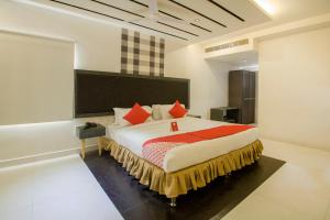 um quarto com uma cama grande e almofadas vermelhas em OYO Hotel Palak Residency Near Erragadda Metro Station em Ameerpet