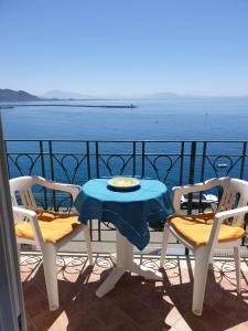 een tafel en stoelen op een balkon met uitzicht op het water bij La casetta sul mare in Vietri