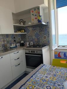 een kleine keuken met een fornuis en een raam bij La casetta sul mare in Vietri