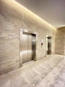 2 ascensores en un vestíbulo con paredes de mármol en Apartemen Sayana Harapan Indah by Cheapinn, en Tambun-lobangbuaja