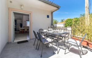 a table and chairs on the patio of a house at Nice Apartment In Jadranovo With 3 Bedrooms And Wifi in Jadranovo