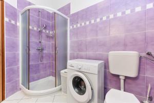 Fioletowa łazienka z pralką i prysznicem w obiekcie House Kacana 2163 w mieście Vodnjan