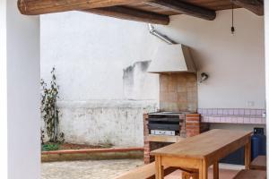 a kitchen with a stove and a wooden table at SanvitoTour - Villa Soffio di Mare in San Vito lo Capo