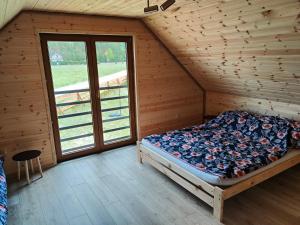 1 dormitorio con 1 cama en una casa de madera en Domek u Lipków na Kaszubach "Oliś" JACUZZI, en Gostomko