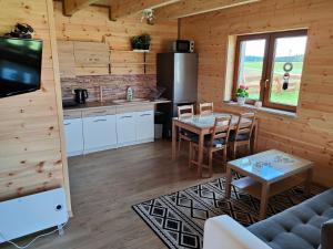 Cabaña de madera con cocina y sala de estar. en Domek u Lipków na Kaszubach "Oliś" JACUZZI, en Gostomko