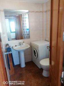 a bathroom with a sink and a toilet and a mirror at Riells playa in L'Escala