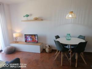 萊斯卡拉的住宿－Riells playa，一间带桌椅和电视的用餐室
