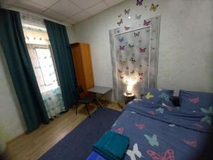 ein Schlafzimmer mit einem Bett mit Schmetterlingen an der Wand in der Unterkunft 1 комнатная квартира в центре Мукачева, улица Мира in Mukatschewo