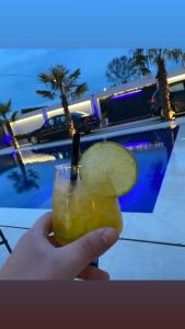 una mano che tiene un drink con una fetta di lime di LT Luxury Villa a Rrushkull