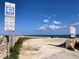 a sign on a beach with the ocean in the background at Alba b&b in Polignano a Mare