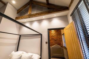 a bedroom with a canopy bed and a brick wall at Town center cottage with Hot tub in Morpeth