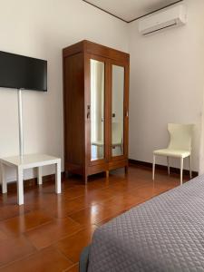 a bedroom with a bed and a cabinet and a chair at la dimora di Enea in Lecce