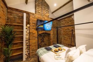a room with a tv and a brick wall at Town center cottage with Hot tub in Morpeth