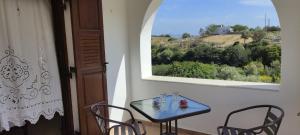 a table and chairs in a room with a window at Votsalo Beach House in Moutsoúna