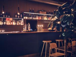 a bar with stools and bottles of alcohol at Hotel Flora in Gothenburg