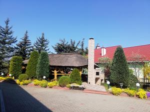 a building with a pavilion with trees and bushes at Noclegi i Restauracja Gracja in Bełchatów