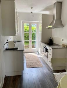 uma cozinha com armários brancos e uma bancada em Cottage am Attersee em Nussdorf am Attersee